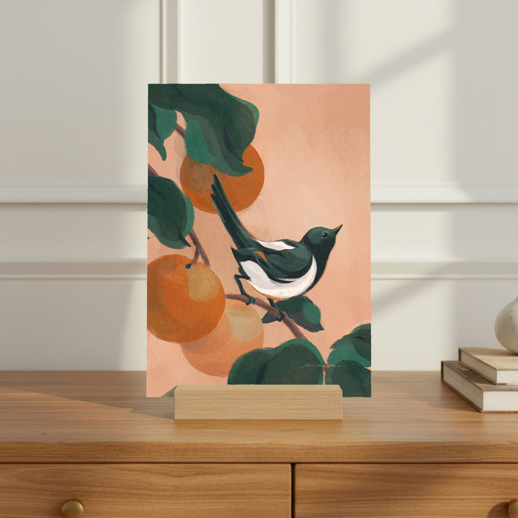 Card with a bird and oranges design on a wooden surface