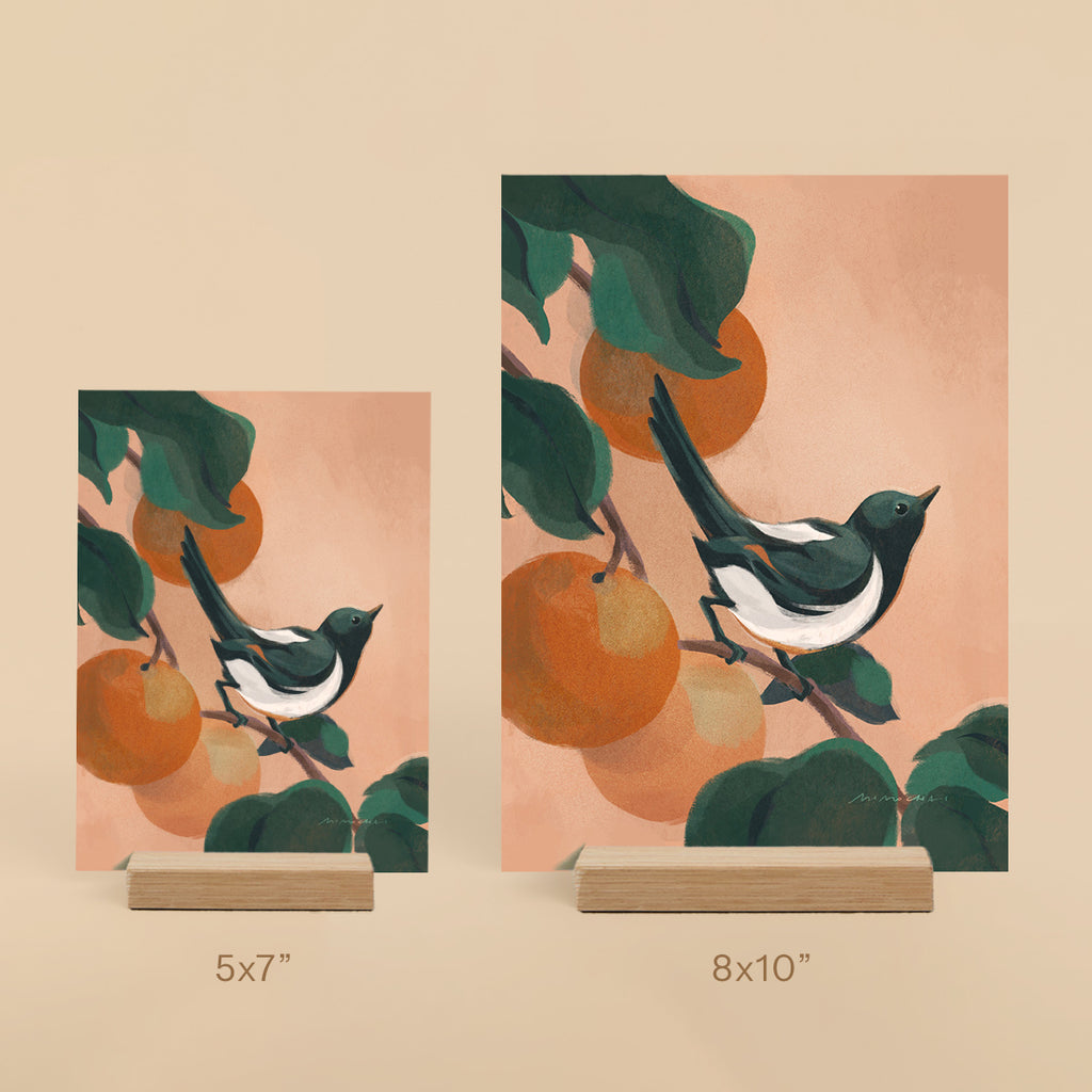 Two illustrated prints of birds on branches with oranges, one 5x7" and one 8x10" on a beige background.
