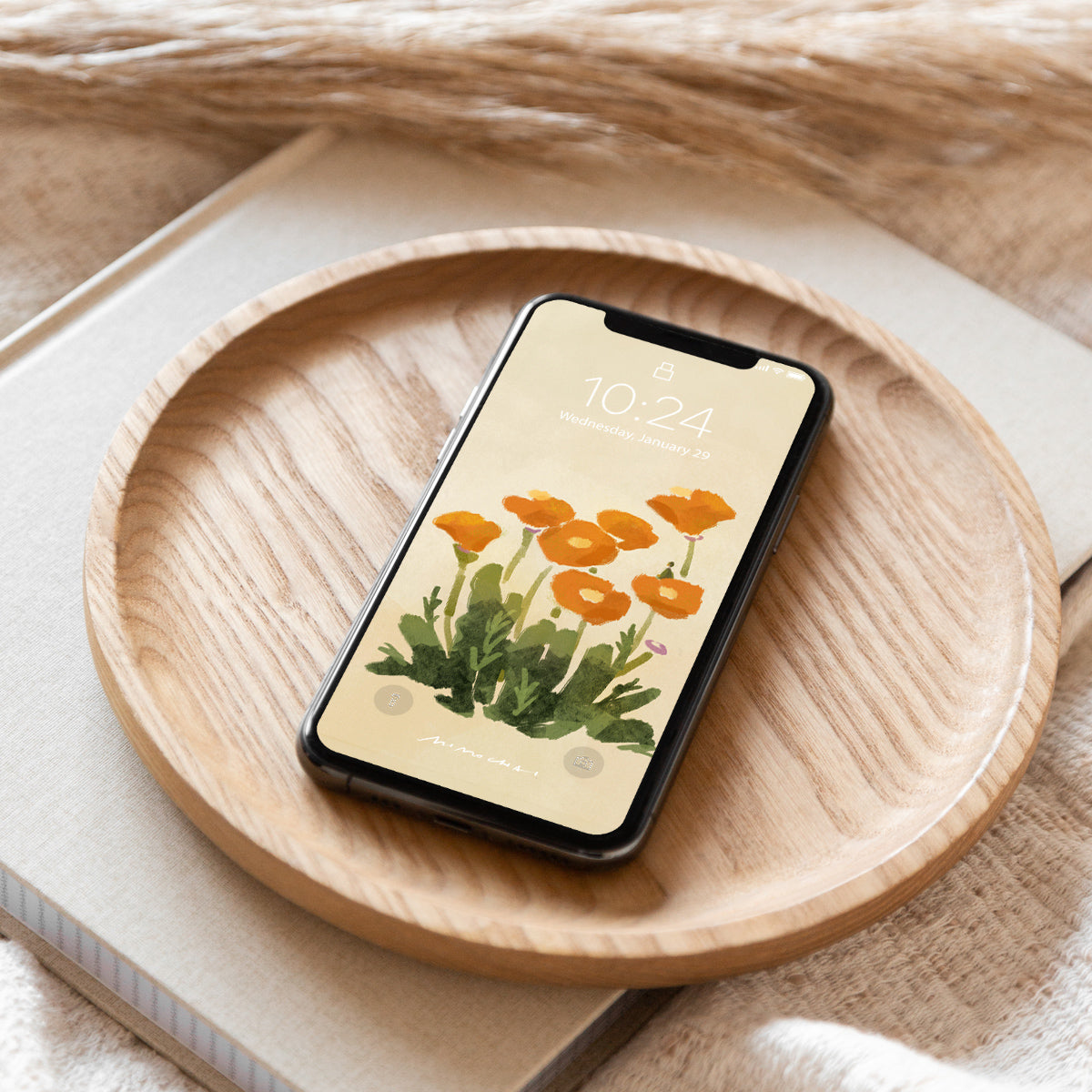 Smartphone with orange flower design on a wooden plate