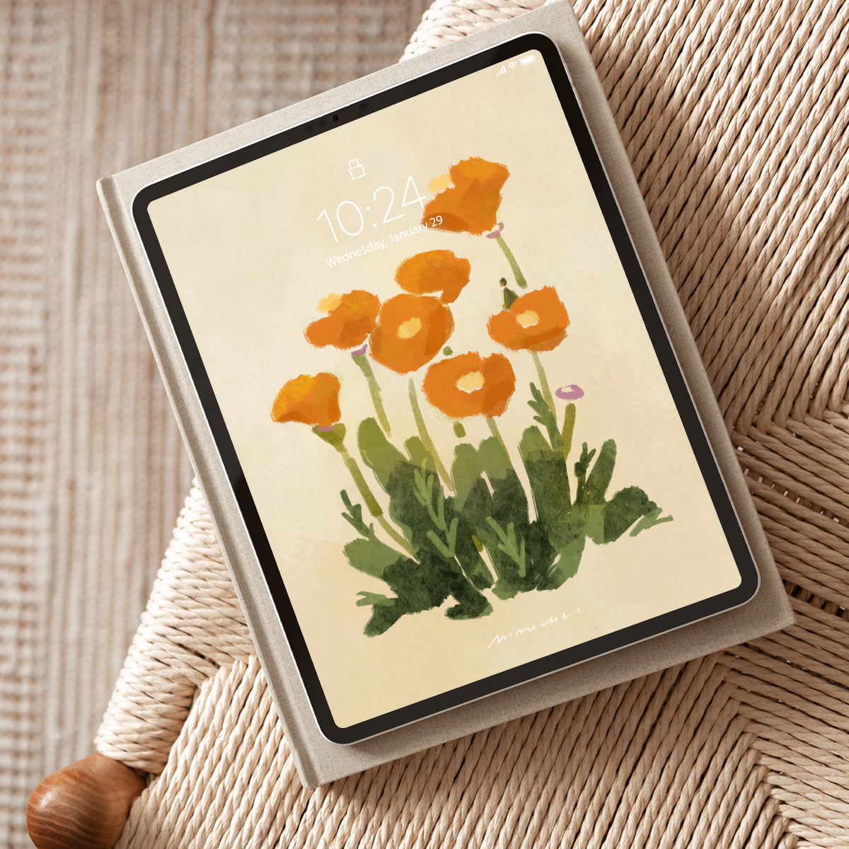Tablet with a floral wallpaper with orange poppies on a beige background.