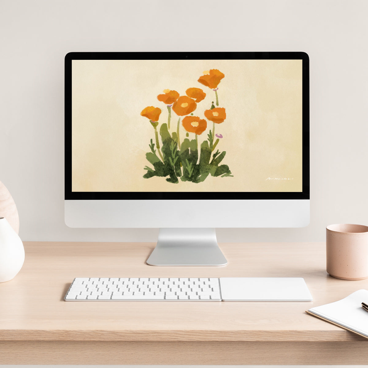 Computer monitor displaying a floral poppy wallpaper on a desk with a keyboard and mug.