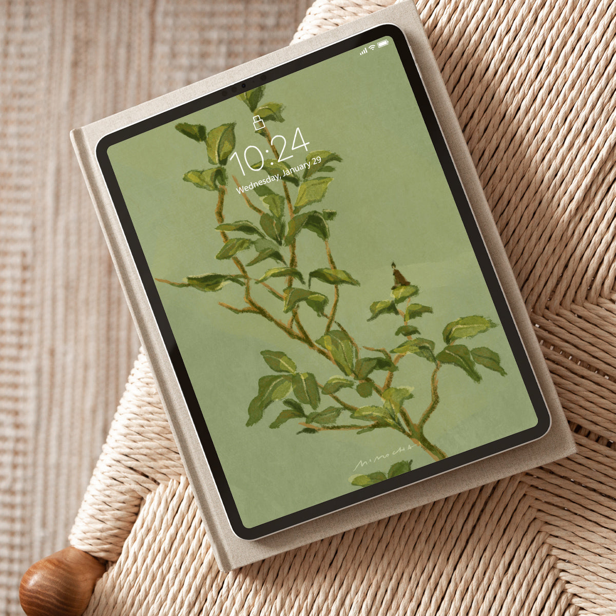 Tablet with a nature-themed Camellia Leaves wallpaper on a chair