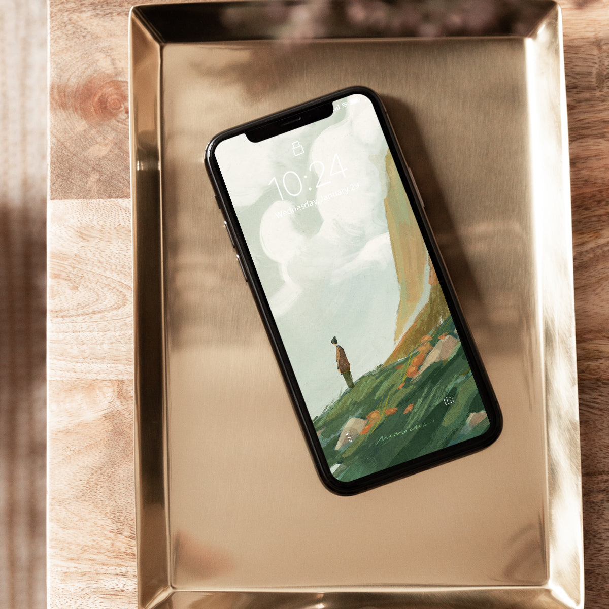 Smartphone with a scenic wallpaper of a person standing on a hill. 