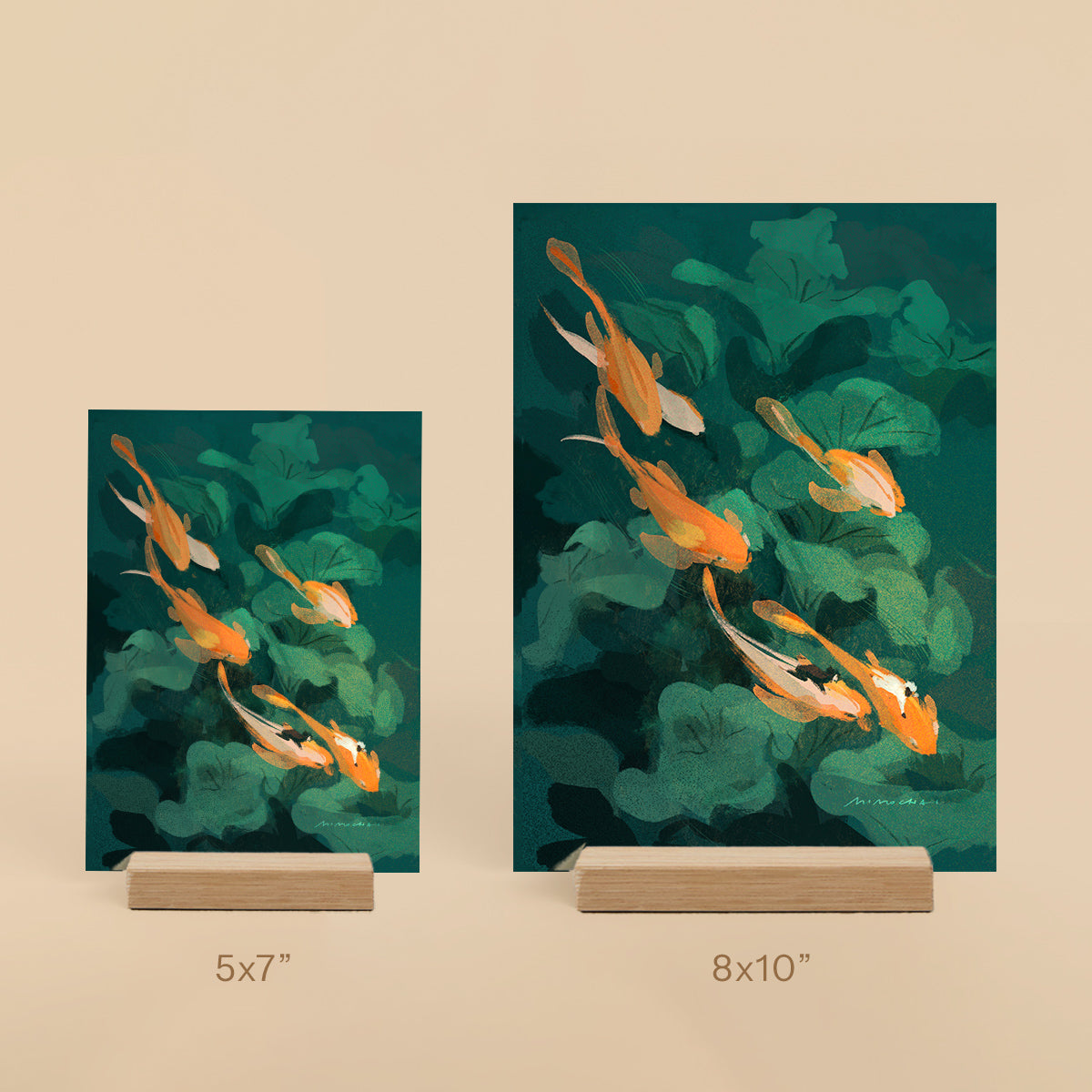 Two art prints of goldfish in water with green leaves on a beige background.
