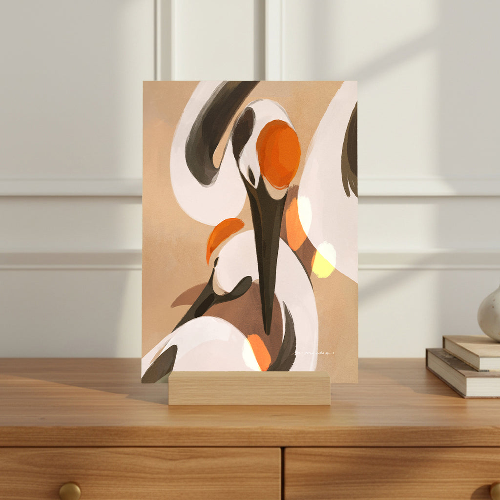 Mini print with an illustration of a mother and baby crane on a wooden surface
