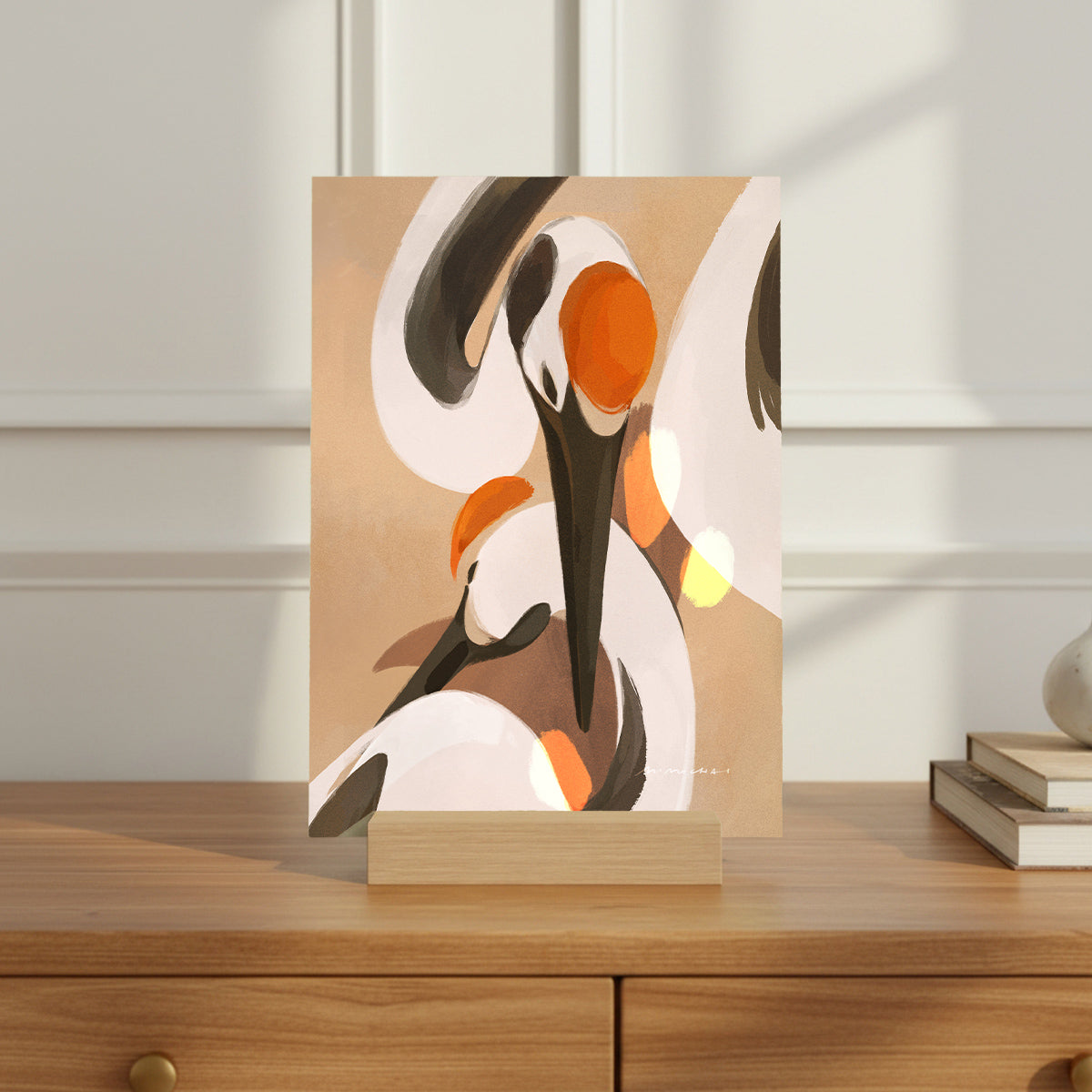 Mini print with an illustration of a mother and baby crane on a wooden surface