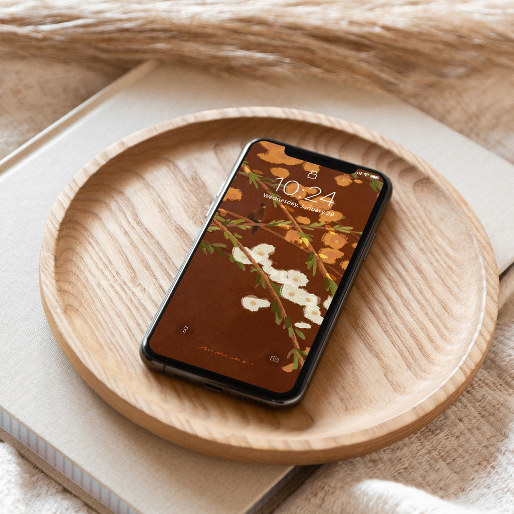 Smartphone with floral screen on a wooden plate