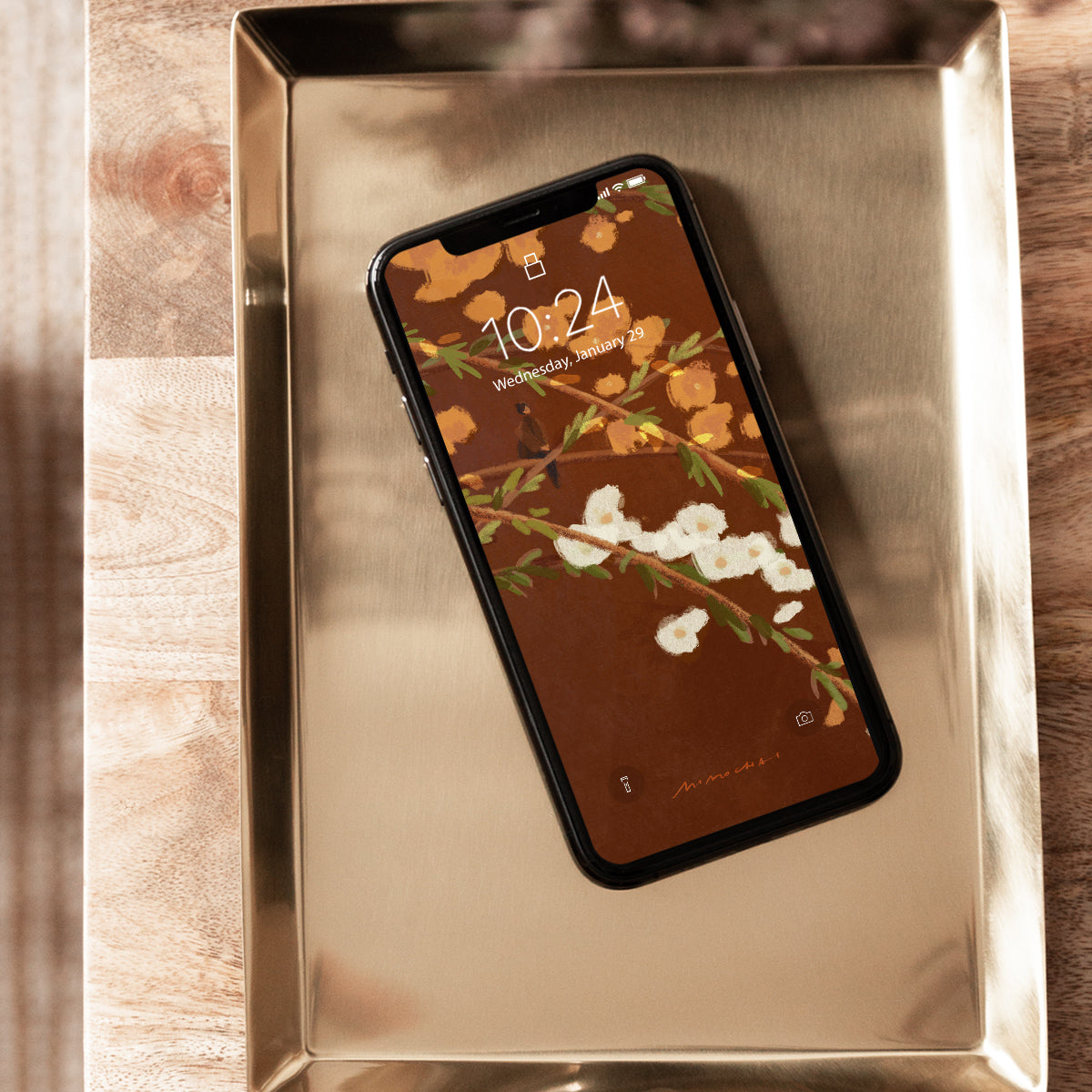 Smartphone with floral screen on a metallic surface