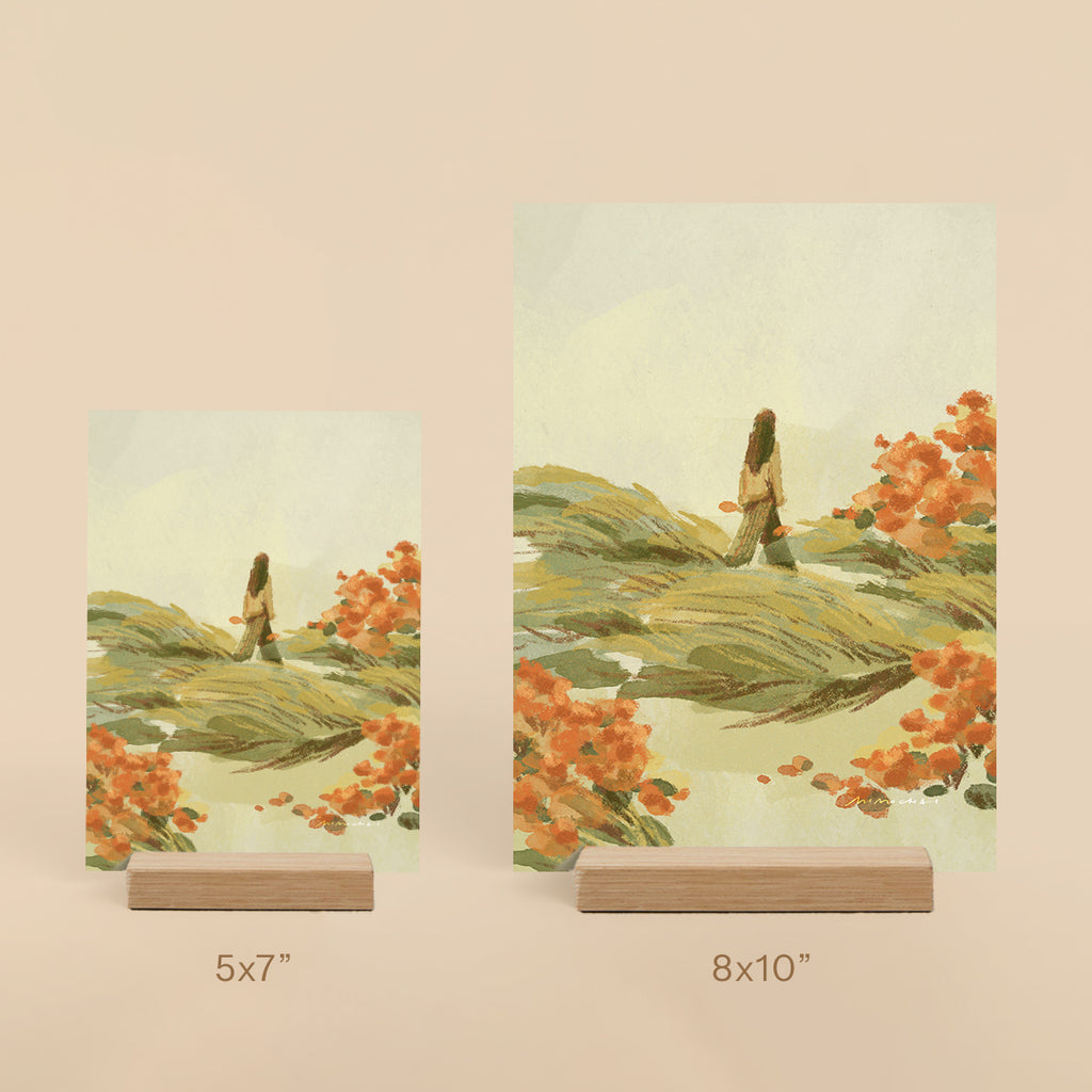 Two art prints of a landscape with a person and trees on stands, one 5x7" and one 8x10".