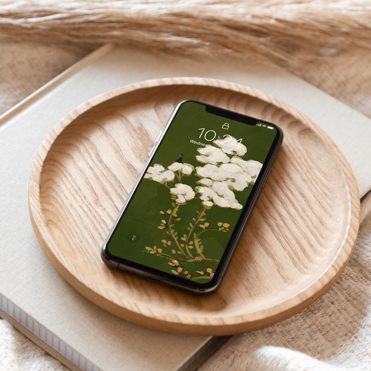 Smartphone with floral screen on a wooden plate