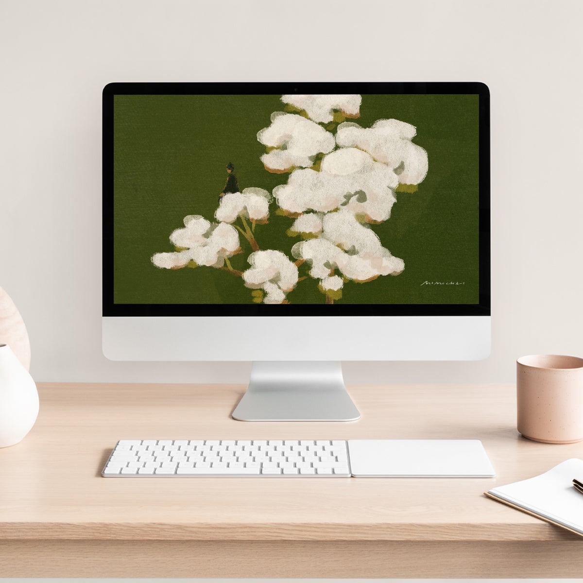 Computer monitor displaying a floral image on a desk with a keyboard and mug.