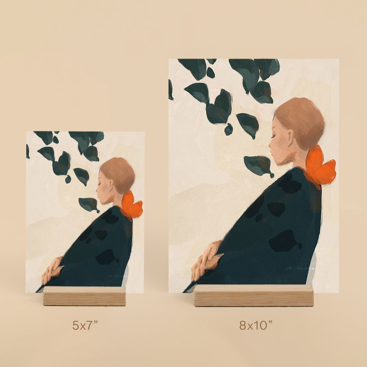 Two art prints of a woman with an orange butterfly on her shoulder on a beige background.
