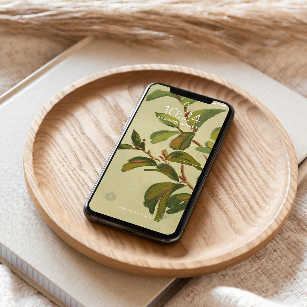 Smartphone with a nature-themed wallpaper on a wooden plate