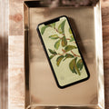 Smartphone with a leafy green lock screen on a metallic tray