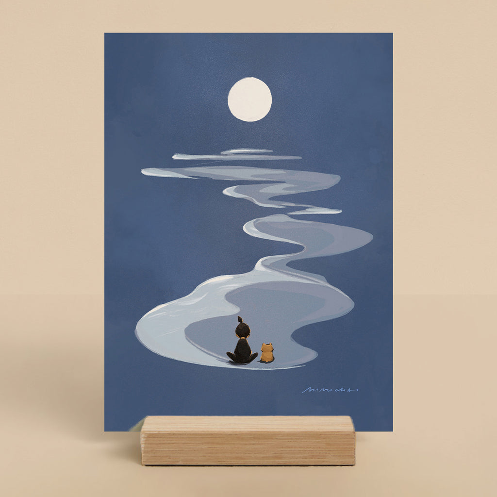 Illustration of a person and a dog sitting on a wave under a full moon, displayed on a stand.