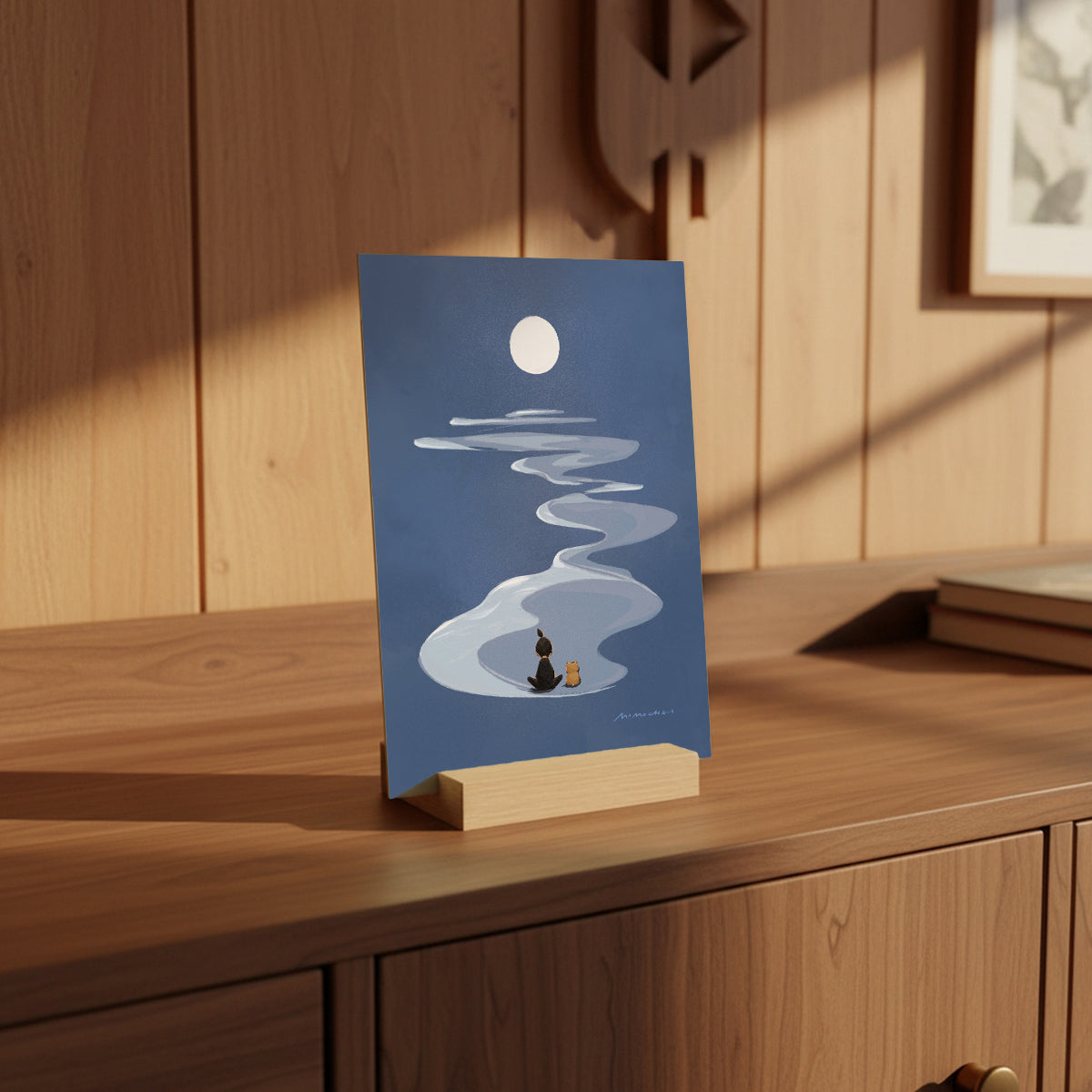 Card with a design of a person sitting under a full moon on a wooden surface