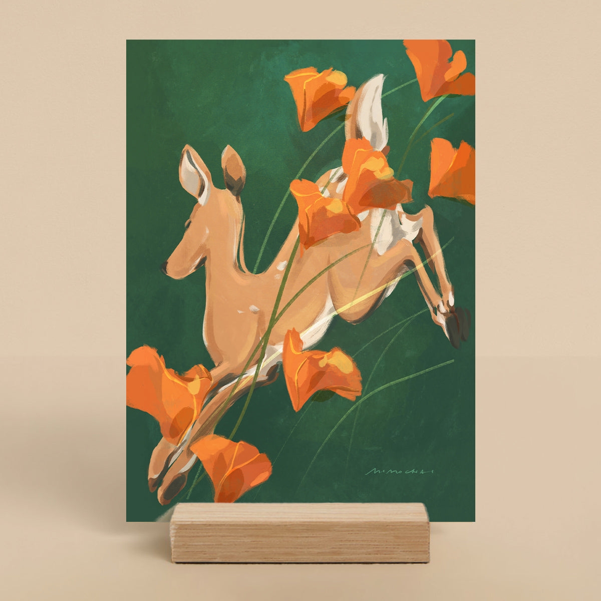 Art print of a deer among orange poppies on a green background, displayed on a wooden stand.