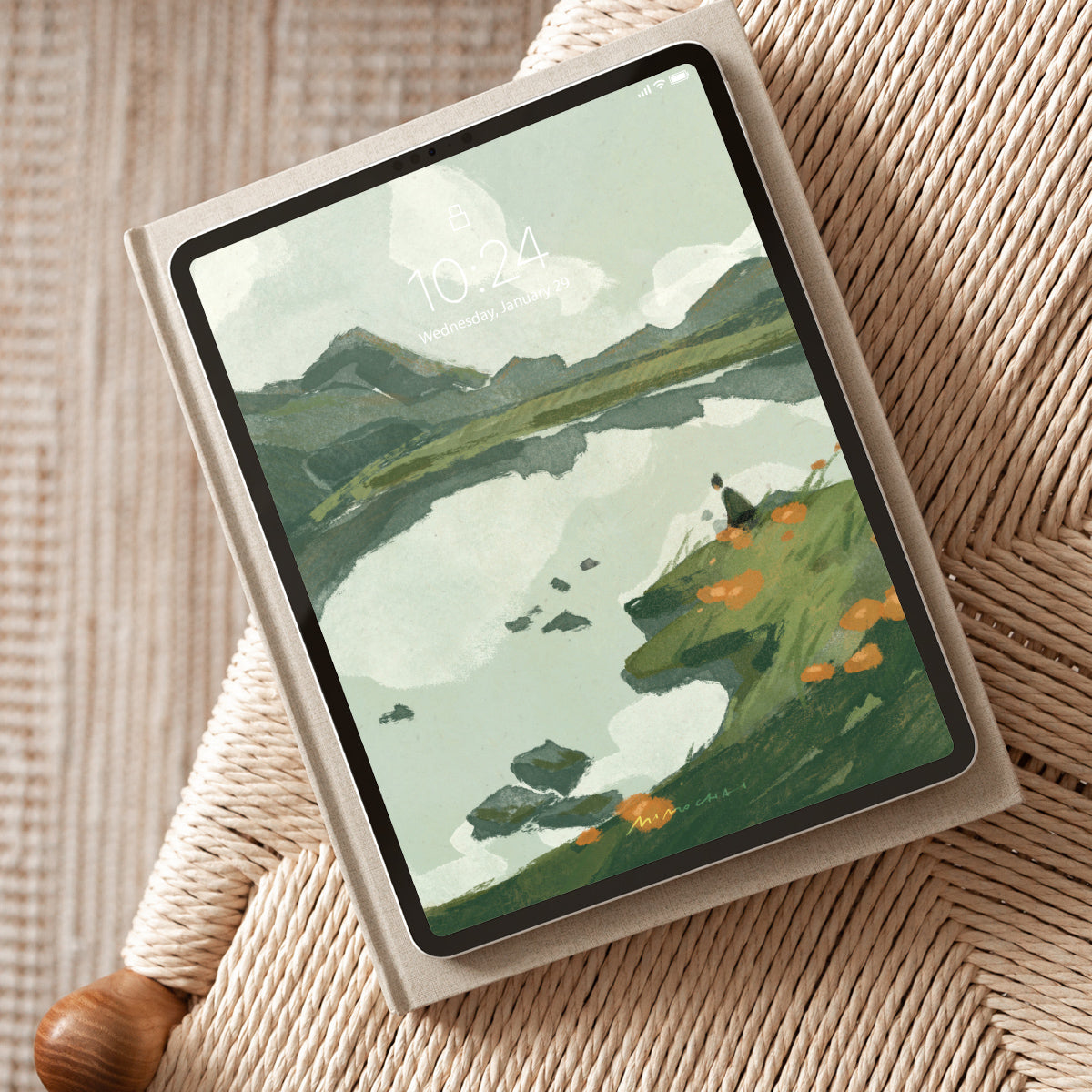 Tablet displaying a scenic lake landscape on a textured surface