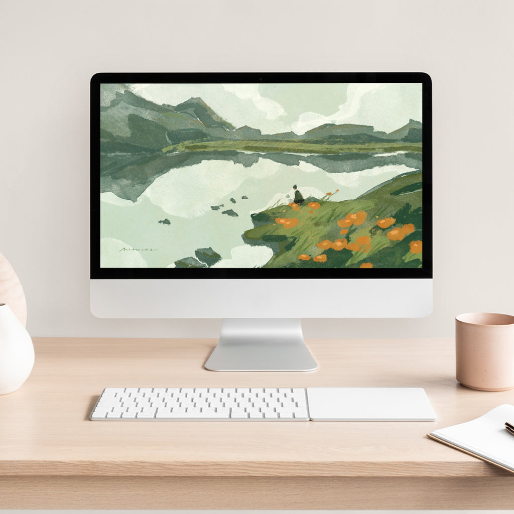 Computer monitor displaying a nature Lake scene on a desk with a keyboard and mug.