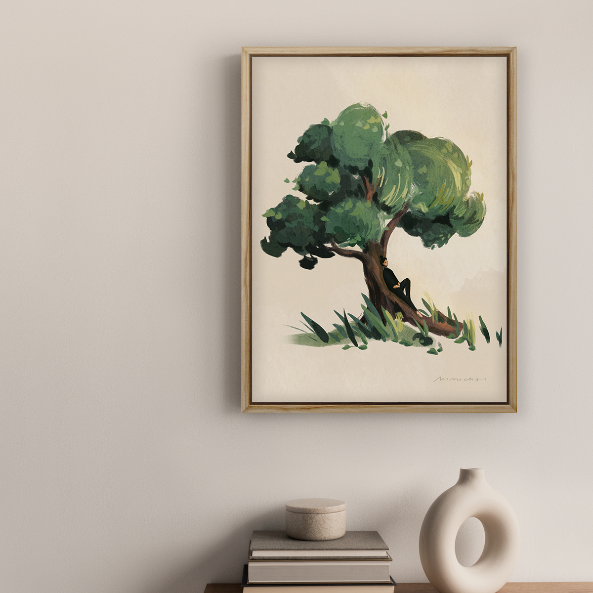 Framed artwork of a tree on a wall above a wooden cabinet with decorative items.