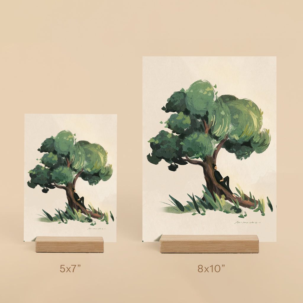 Two tree paintings on stands with size labels against a beige background
