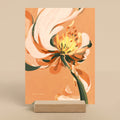 Orange floral art print on a stand against a beige background