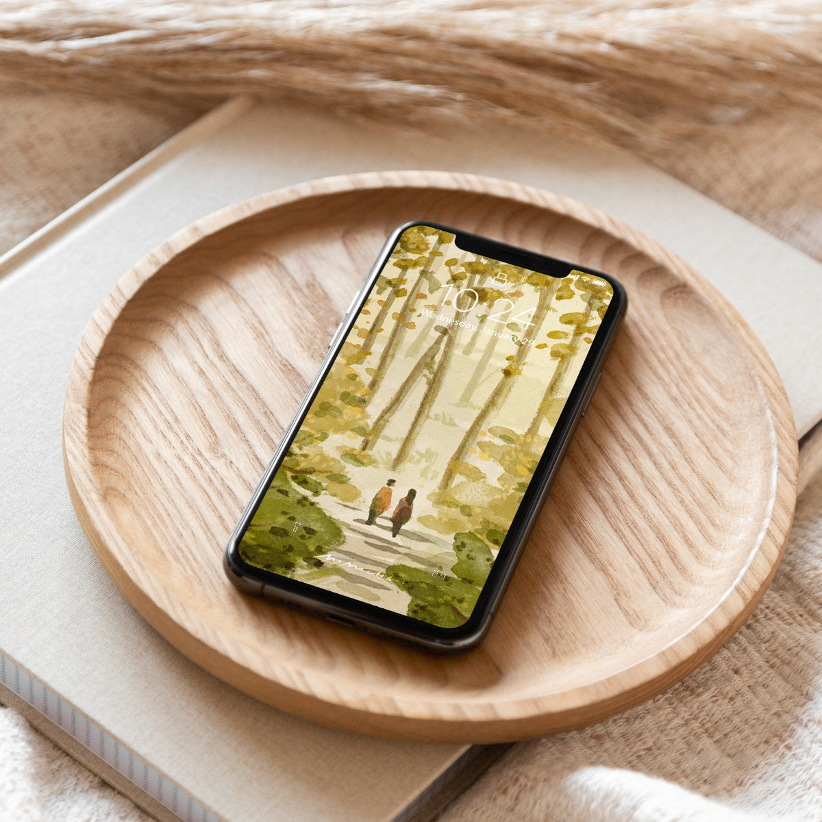 Phone with nature-themed wallpaper on a wooden plate