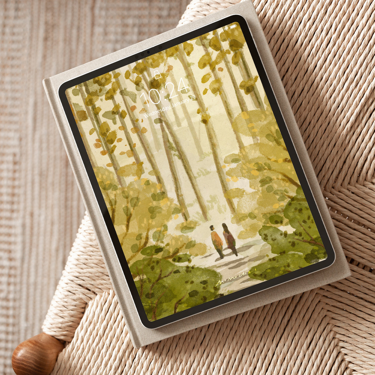 Tablet with a nature-themed cover featuring two people in a forest on a textured surface.