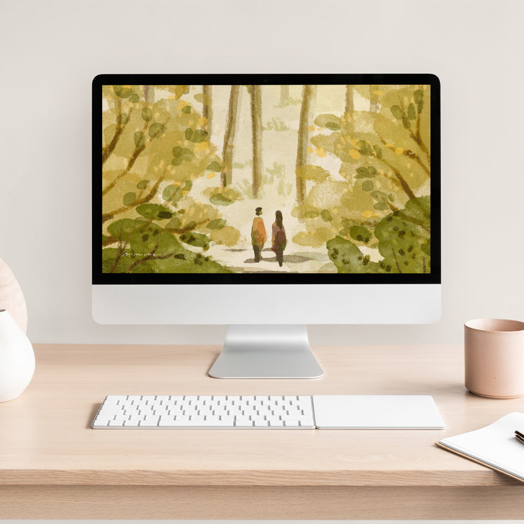 Computer monitor displaying a nature-themed wallpaper with two people in a forest, on a desk with a keyboard and mug.