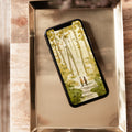 Phone with nature-themed case on a metallic tray