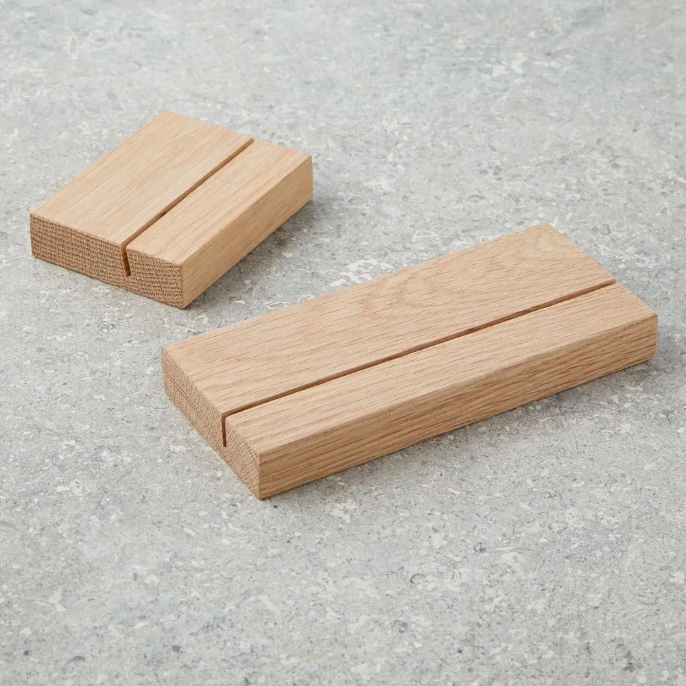 Two wooden picture stands on a gray concrete surface