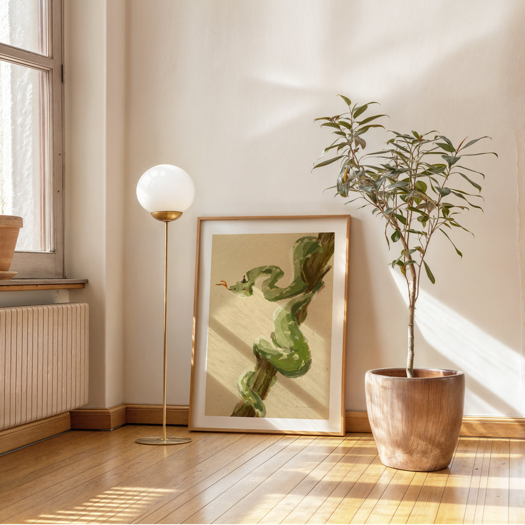 Modern interior with a plant, framed artwork of a green snake for Year of the Snake, and floor lamp.