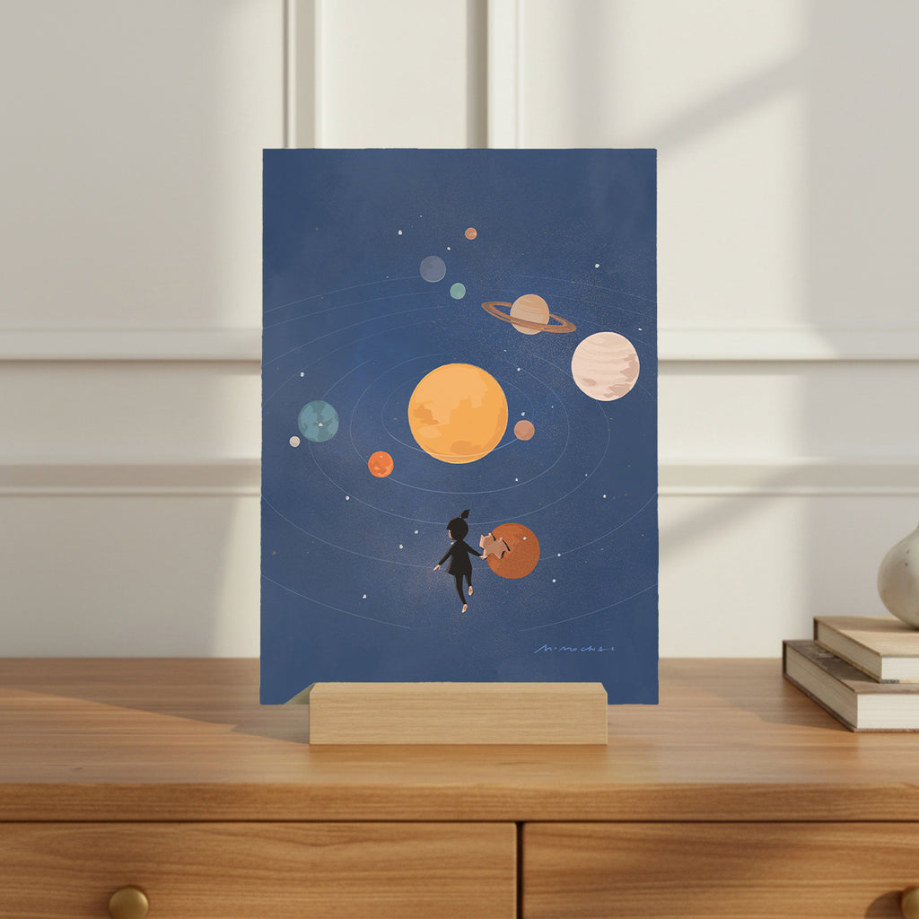 Illustration of a person with a dog looking at planets on a blue background, displayed on a wooden surface.