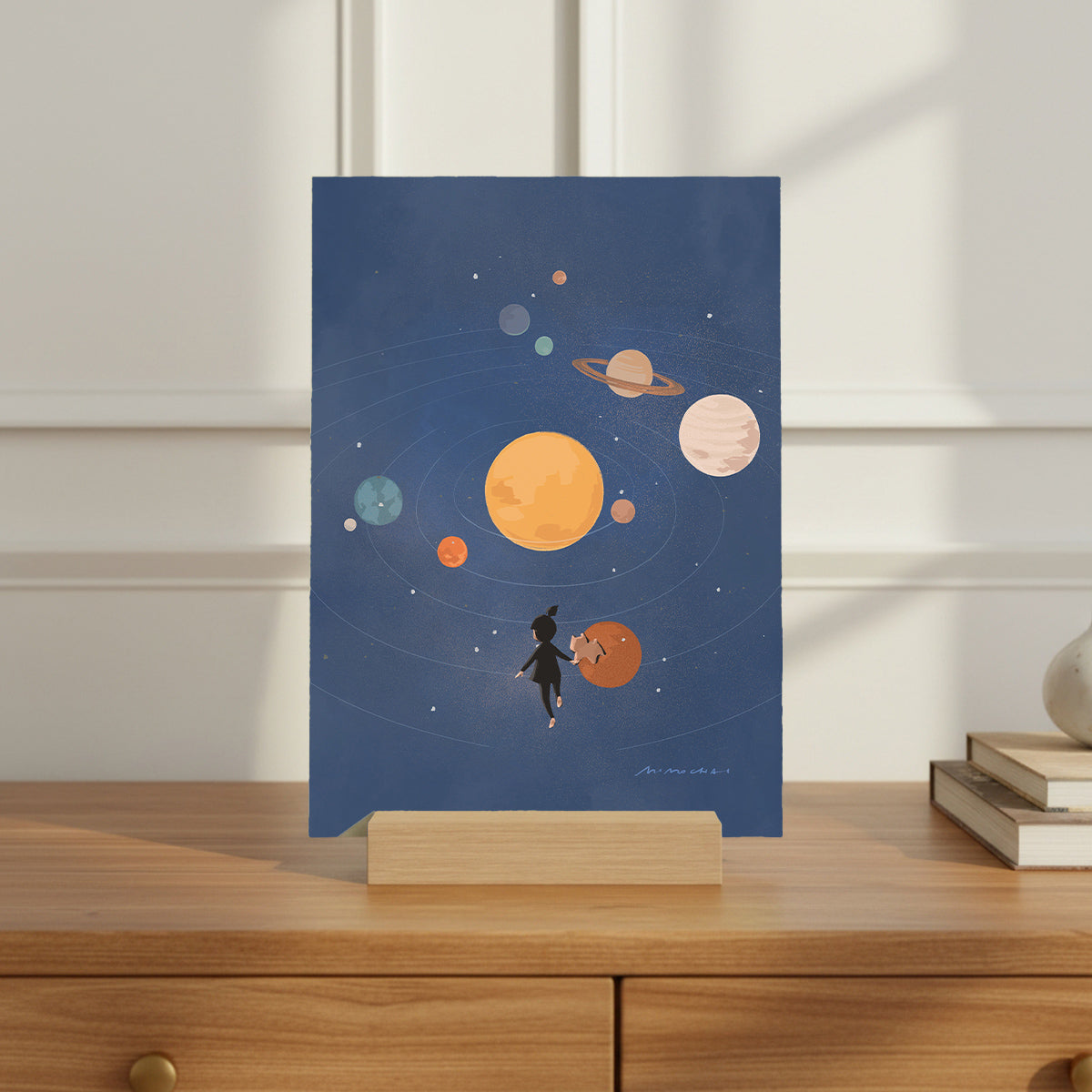 Illustration of a person with a dog looking at planets on a blue background, displayed on a wooden surface.