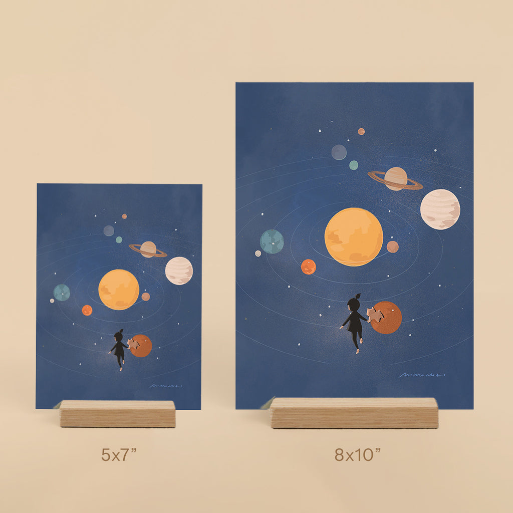 Two framed illustrations of planets and a little girl on a beige background